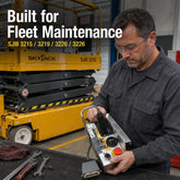 Technician inspecting a SAIYIS 156879 control box in a workshop with a Skyjack SJIII scissor lift in the background