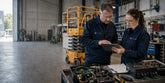 SAIYIS technicians reviewing an aerial work platform control system in an industrial workshop