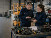 SAIYIS technicians reviewing an aerial work platform control system in an industrial workshop